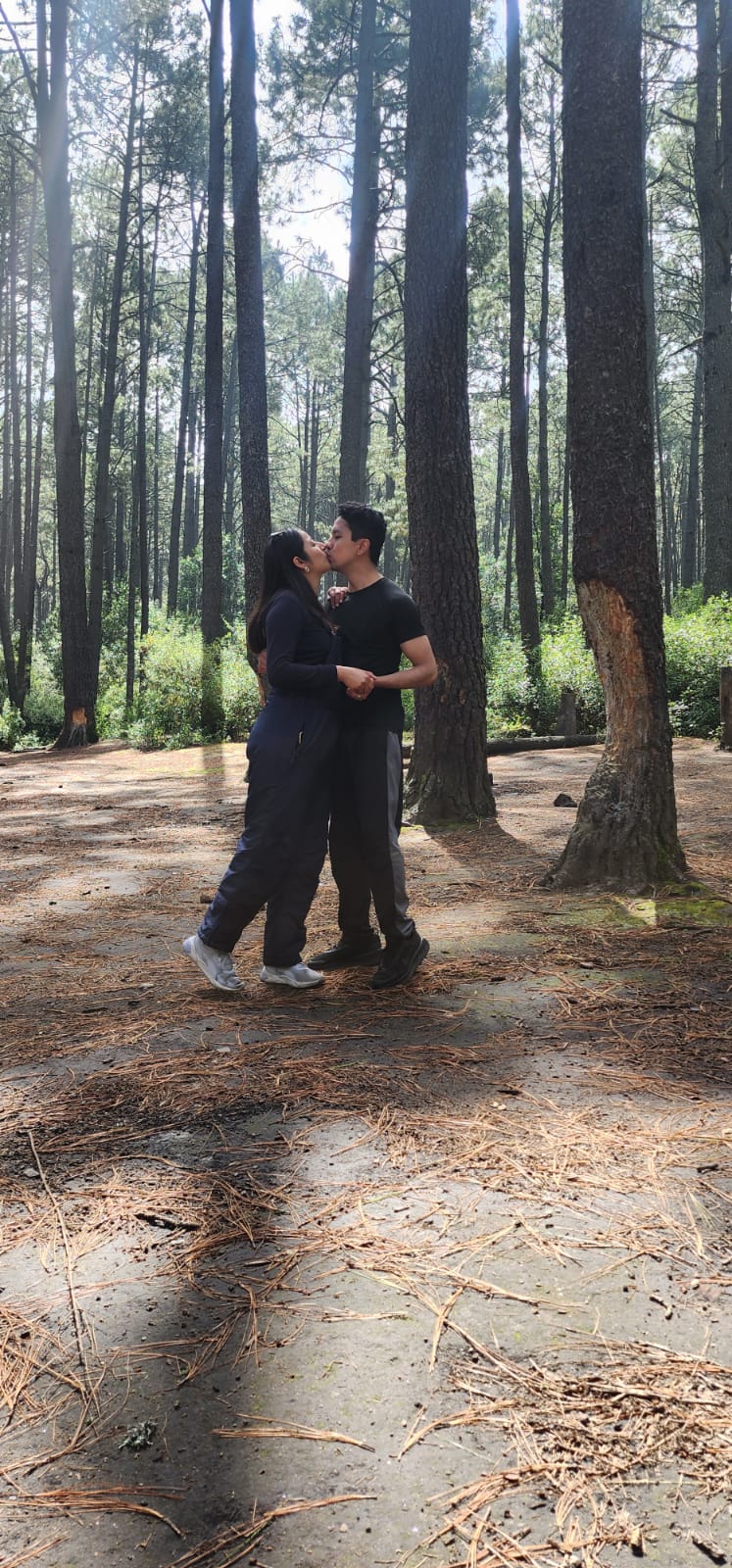 Los dos abrazados en un bosque de árboles altos