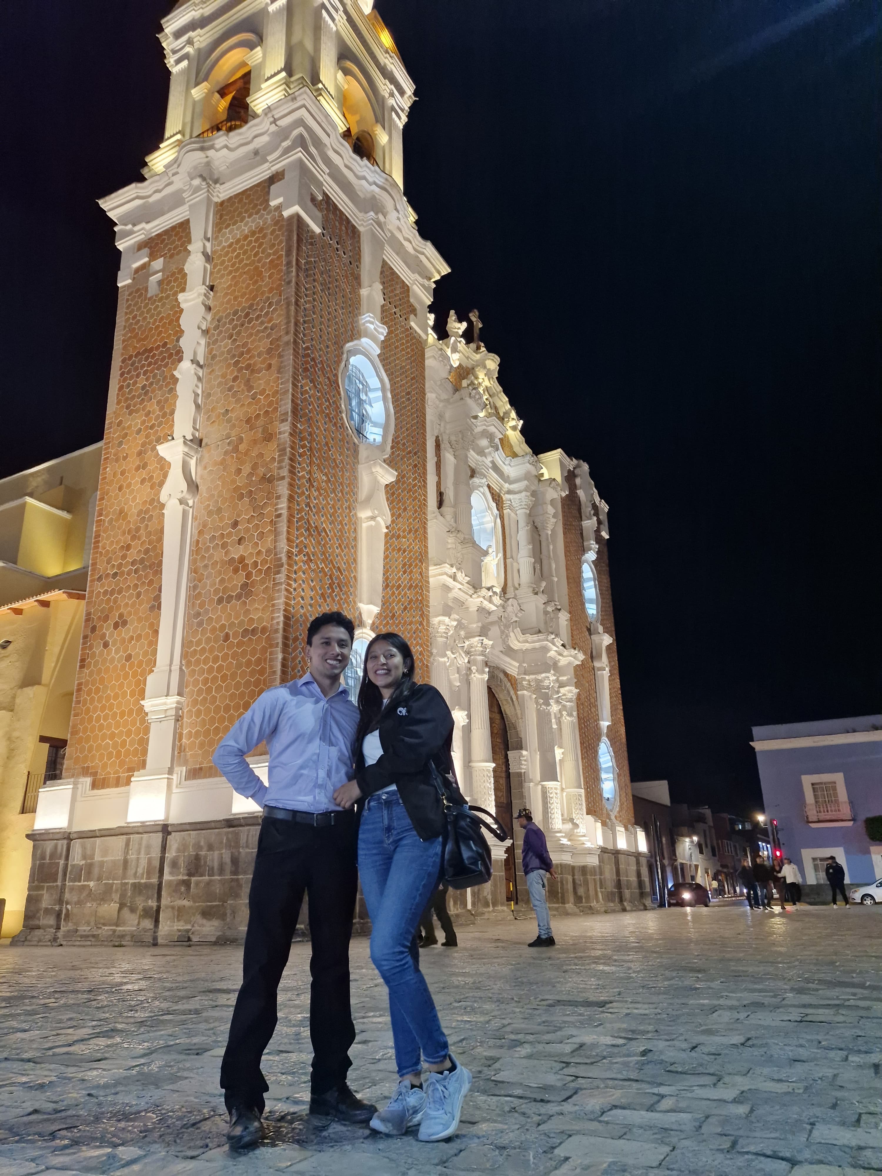 Los dos juntos de noche frente a un templo iluminado